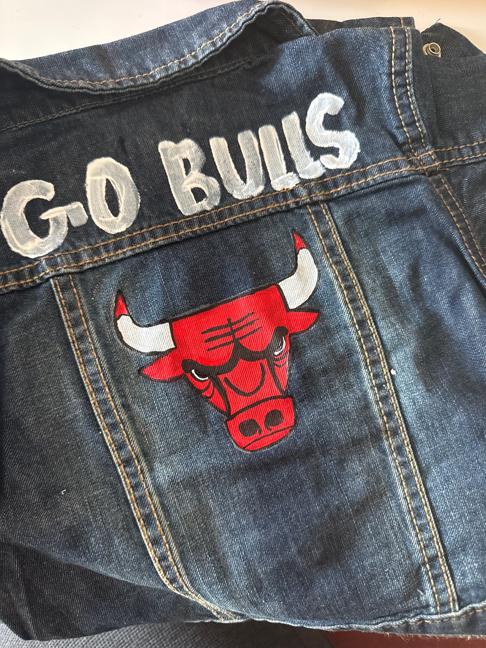 Denim jacket with 'G-O BULLS' text and a red bull logo on a plain background