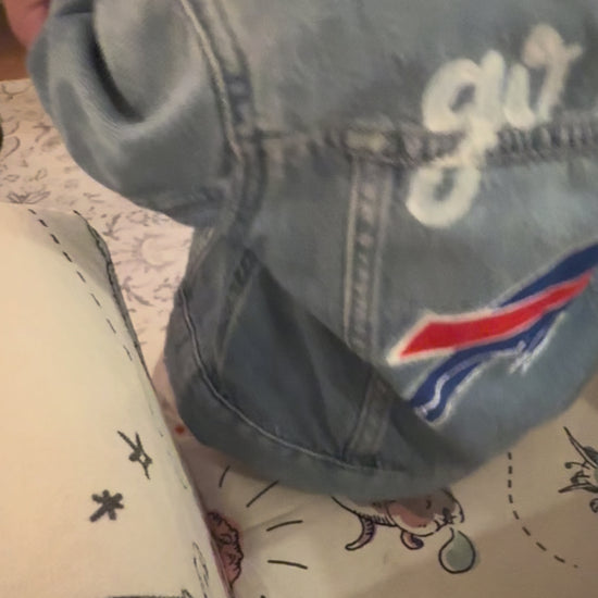 video panning the back of a jacket that reads go bills in script cursive