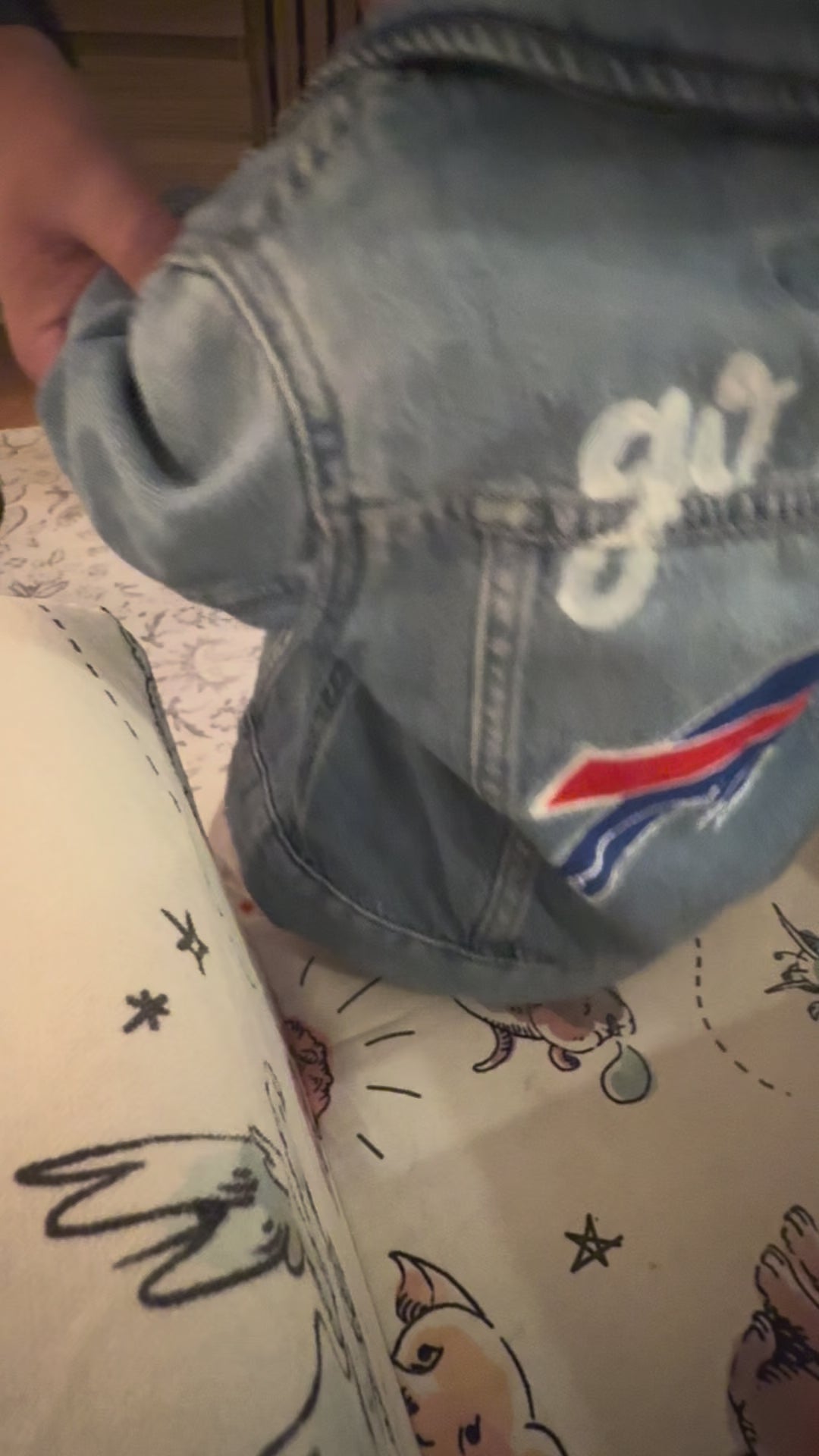 video panning the back of a jacket that reads go bills in script cursive